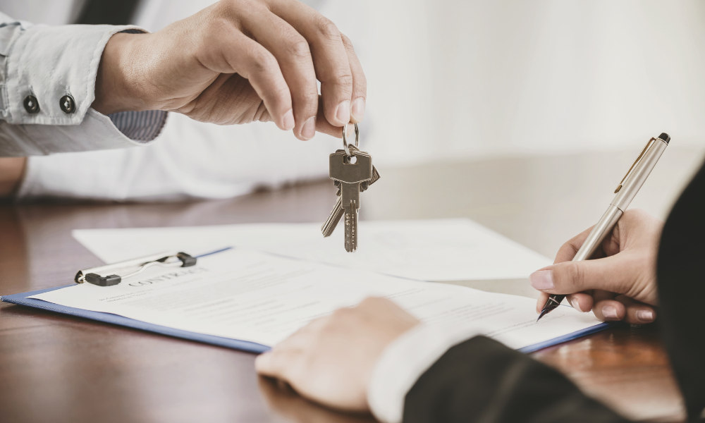 Key Lease Clauses for Commercial Tenants Blog Person signing a Lease Contract and someone hands over a set of keys.